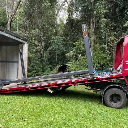 Steel beams and pipes on red tow truck in rainforest