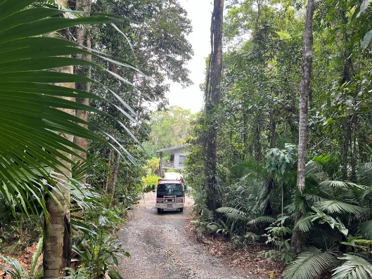 Red tow truck on a narrow rainforest driveway in Kuranda