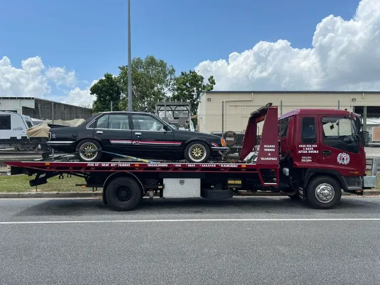 Black sports car on red tow truck, Cairns